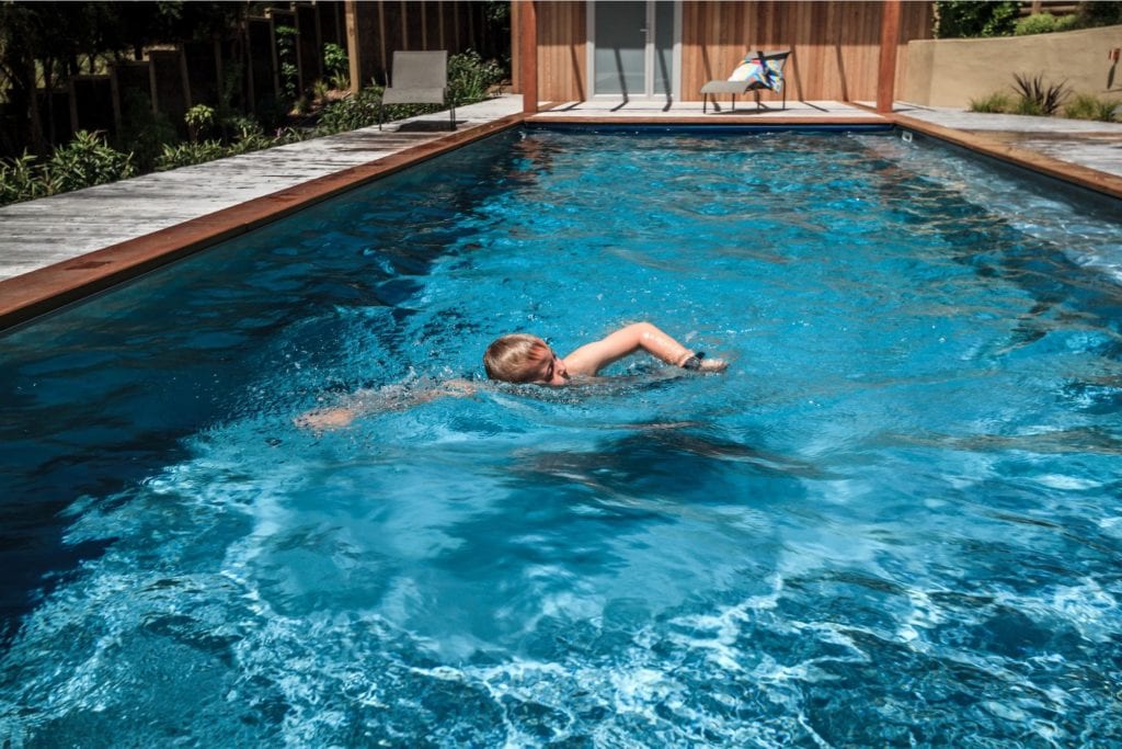 Boy swimming in chemical free swimming pool